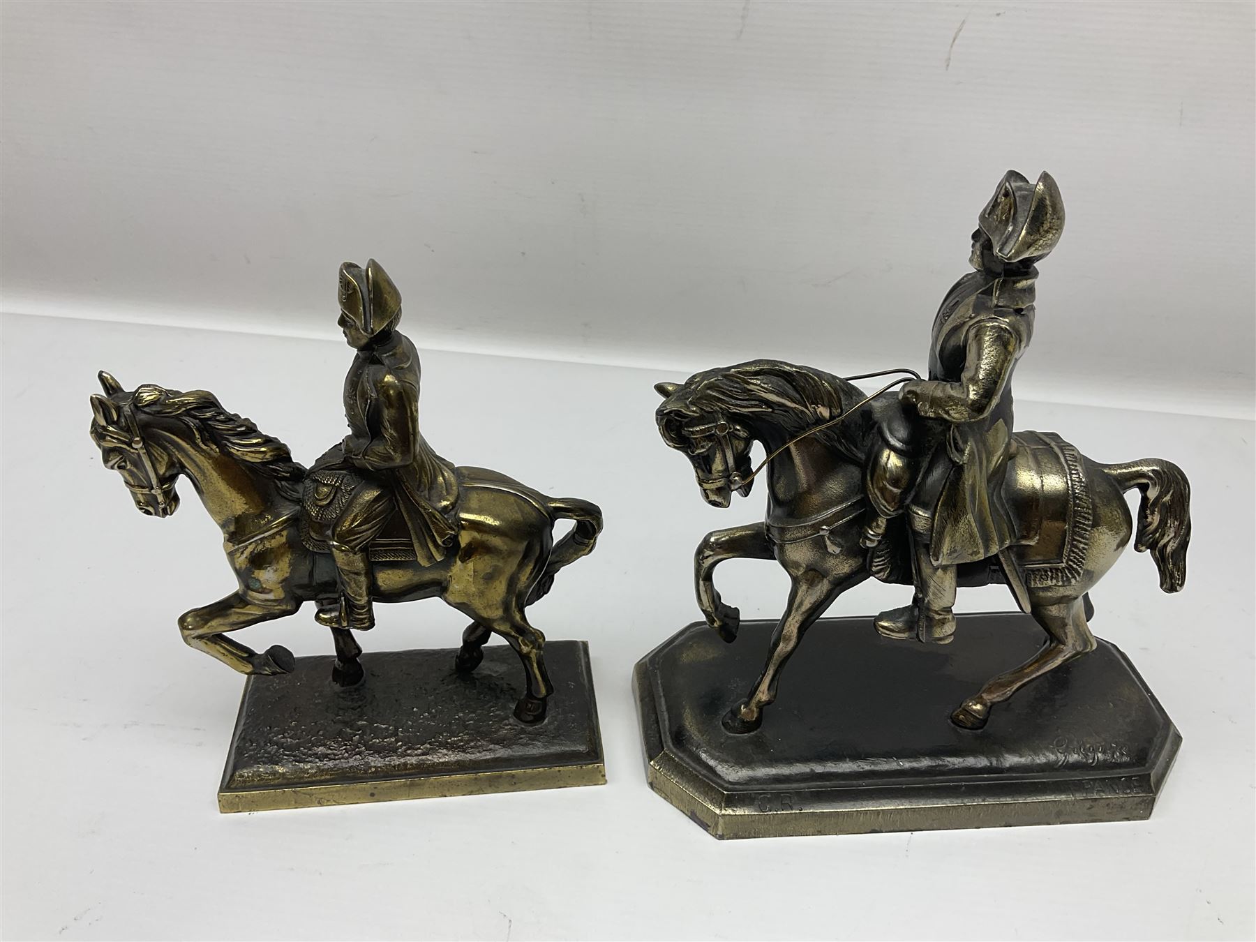Two figures of Napoleon on horseback, one example standing on octagonal bases marked 'G R France' indistinctly signed, the other on a rectangular base, H19cm 