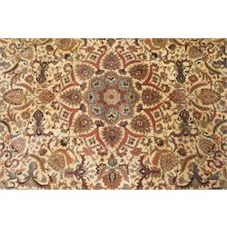 Persian Isfahan ivory and crimson ground rug, the busy field with central floral pole medallion surrounded by foliate motifs and stylised palmettes, the indigo guard line with repeating scrolling plant motifs