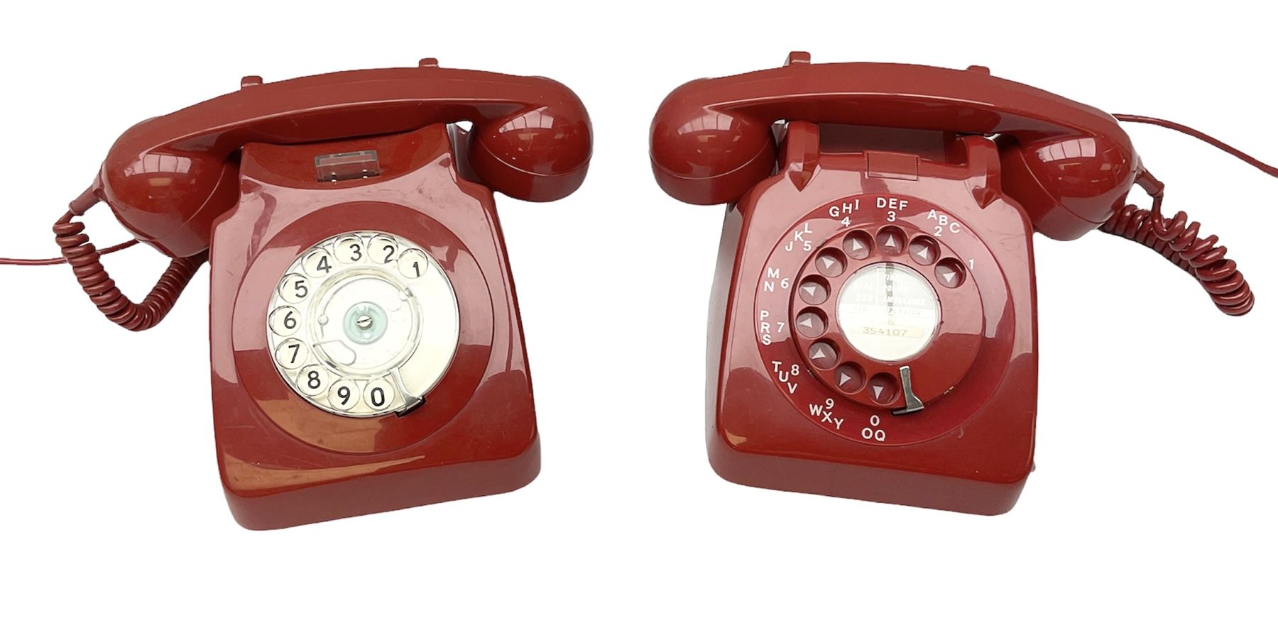 Two mid 19th century red telephones with rotary dials, comprising example marked G.P.O Batch Sampled 8532 706L AEG 67/2A, with junction box marked G.P.O, and another with chrome dial marked P.O Authorised Release 21034 746F EET 78/2