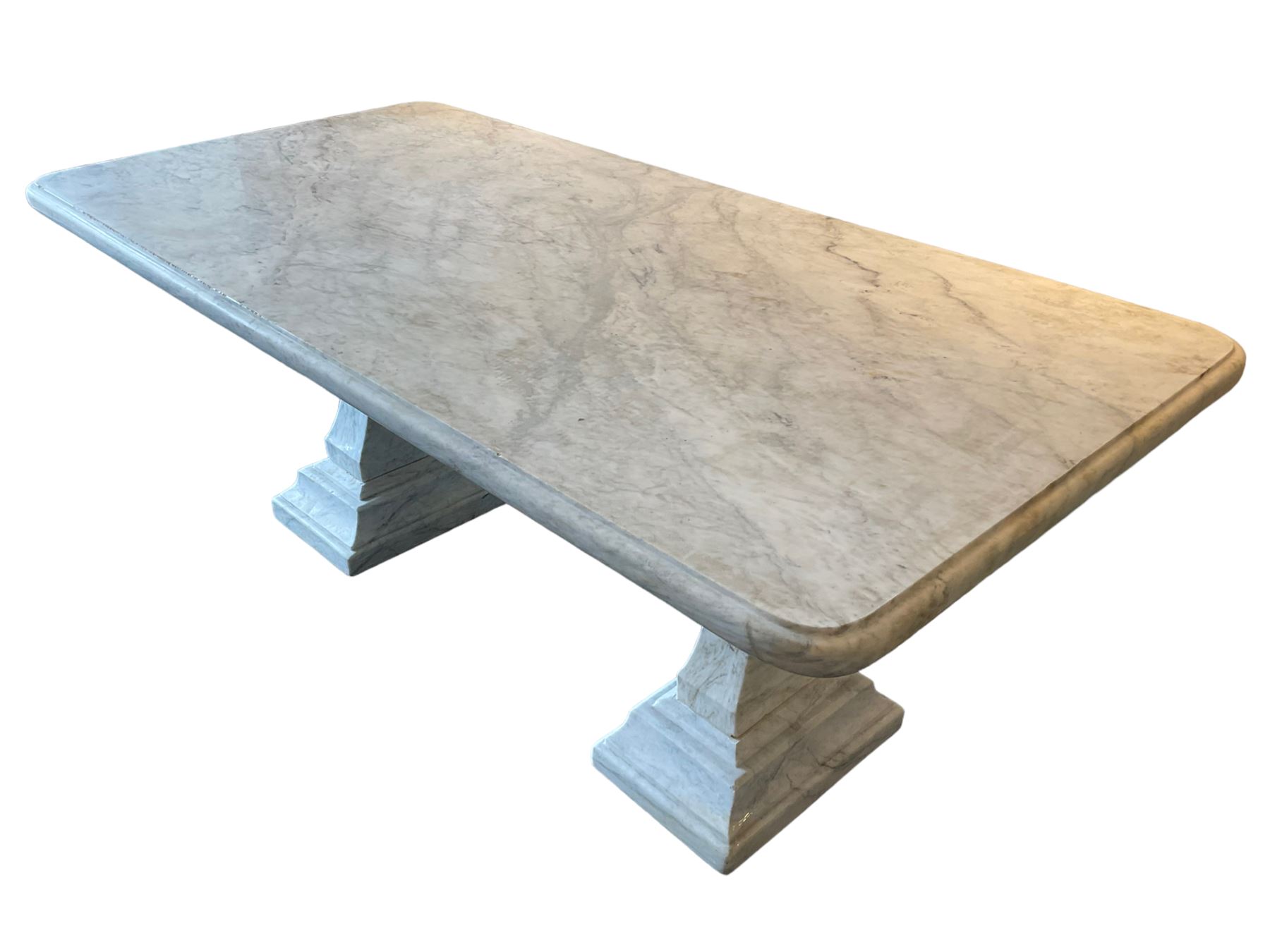 Classical Grecian design Carrera marble centre table, the rectangular single slab top with rounded corners and carved edge, raised on twin pedestals comprised of three pieces with a waisted column on a stepped plinth