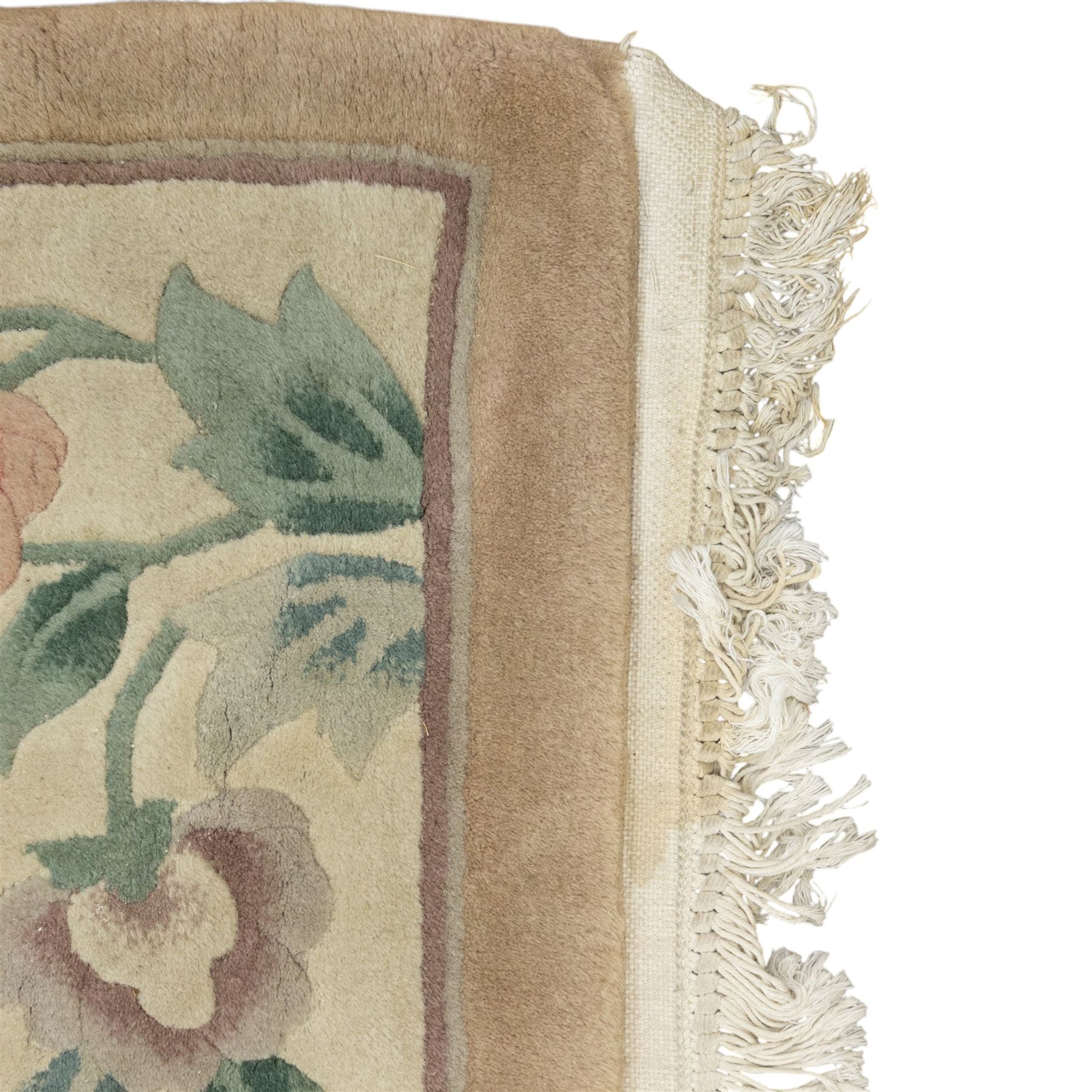 Chinese wool rug, beige ground decorated with peonies, flowering branches and butterflies, centred by a shou symbol within key pattern surround, cream border with floral sprays and double happiness motifs, cotton fringe ends