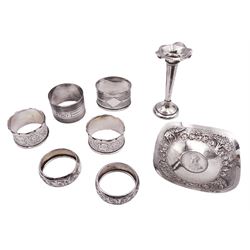 Six silver napkin rings, to include Victorian pair with engraved scrolling decoration, hallmarked Thomas Hayes, Birmingham 1893, a 1930's oval example with engine turned decoration, hallmarked Henry Griffith & Sons Ltd, Birmingham 1933, and a circular engine turned example, stamped Sterling, together with a small Edwardian silver specimen vase, hallmarked James Deakin & Sons, Sheffield 1907, and an early 20th century silver dish inset with Rupee, stamped Sterling Silver, approximate weighable silver 5.17 ozt (160.9 grams)