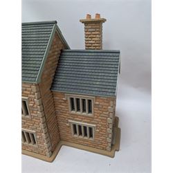 1:24 scale stone effect three-storey cottage dolls house, with green arched door and lattice effect windows, decorated to the interior with wooden floors, wired lighting and fire places, H45cm, W57cm, D26cm
