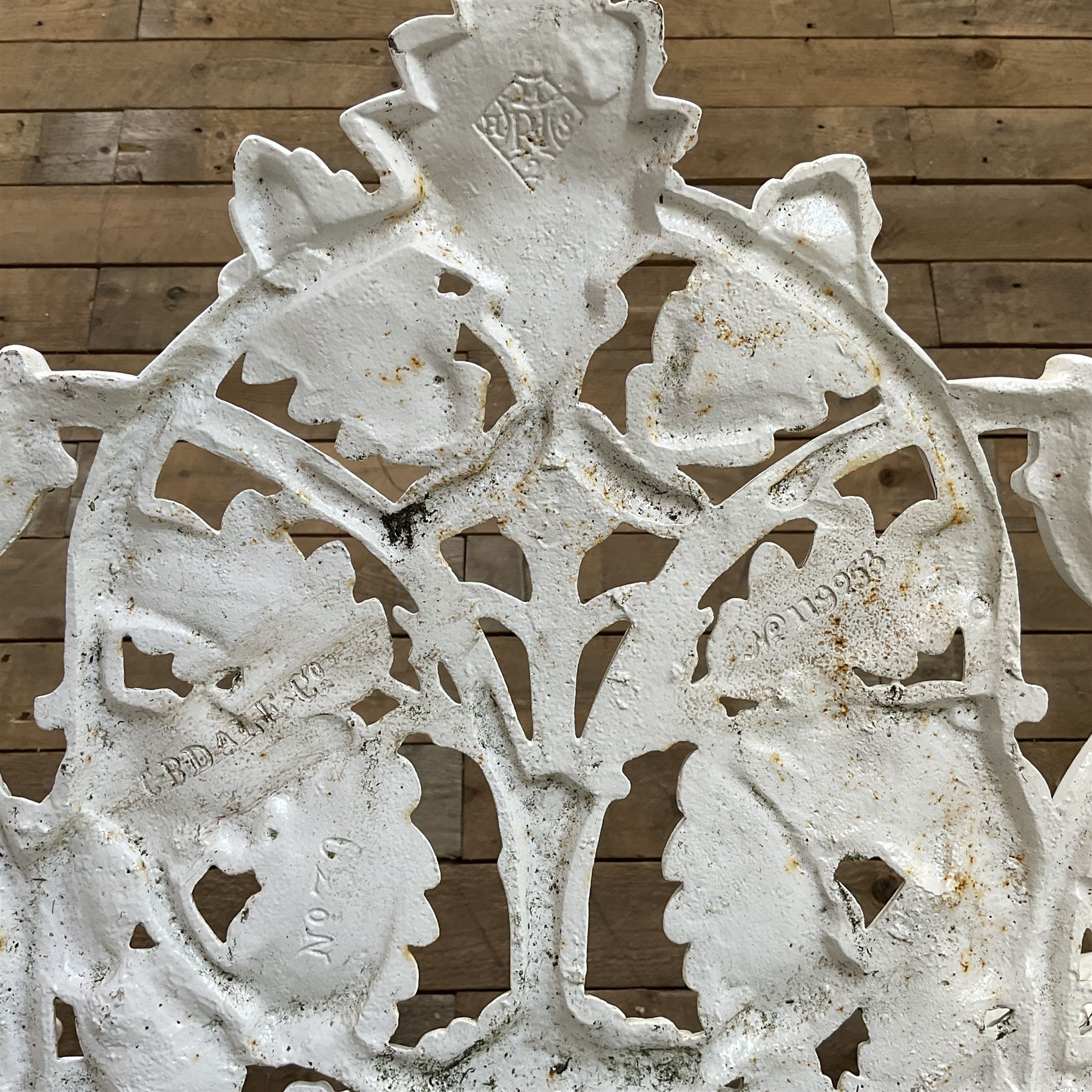 20th century Coalbrookdale design cast iron oak leaf and acorn armchair, white painted cast iron frame with slatted wooden seat, the pierced and shaped back decorated with scrolling oak branches and leafage, flanked by dog mask arm terminals over cabriole supports with paw feet