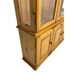 Pine display cabinet, enclosed by glazed doors, fitted with three cupboards