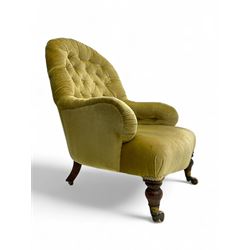 Late 19th century button-back nursing chair, upholstered in olive-green velvet, shaped back with padded arms, raised on turned front supports terminating in castors