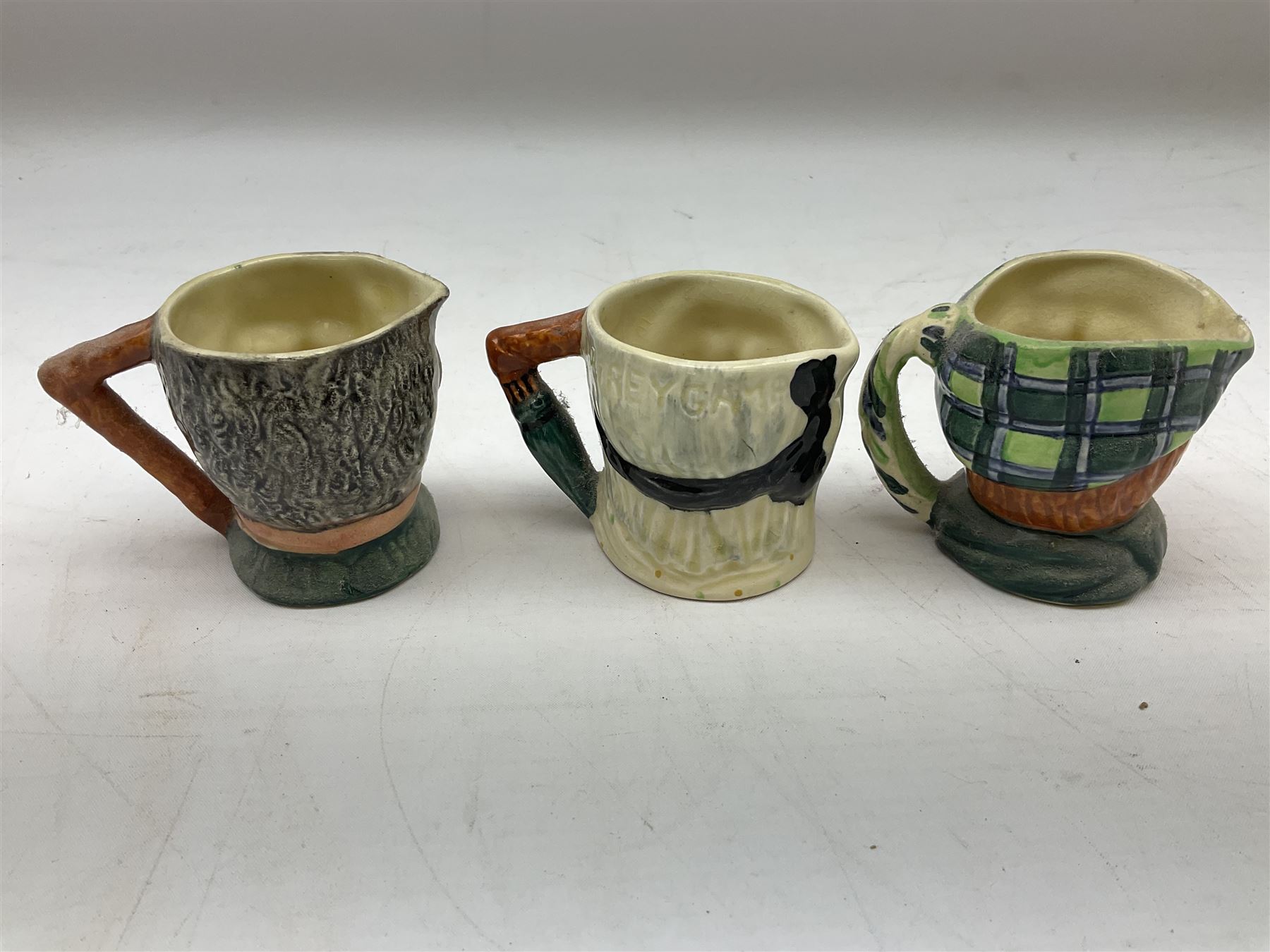 John Beswick figure of a seated piglet, Beswick Beatrix Potter Mrs Rabbit and Peter figure, and quantity of Sandland Character Ware jugs