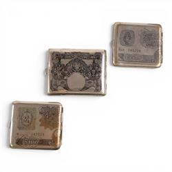 Three cigarette cases, modelled as bank notes, together with a smokers set including ashtray, cigarette case, ligher and cigarette holder, cased and other cigarette holders 
