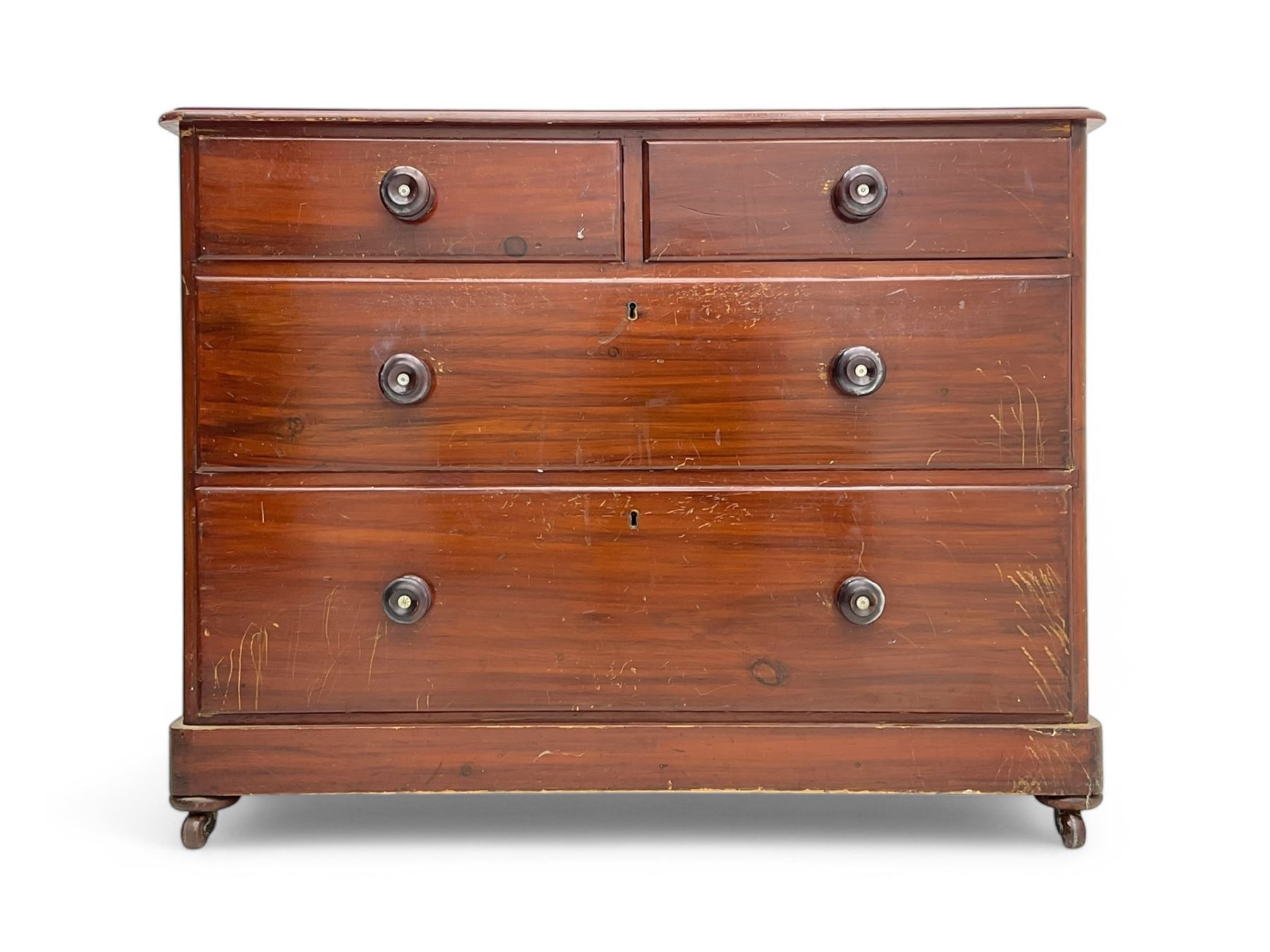 Victorian 19th century stained pine chest of drawers, rectangular top above two short and three long drawers with turned wooden handles, raised on bun feet with castors.