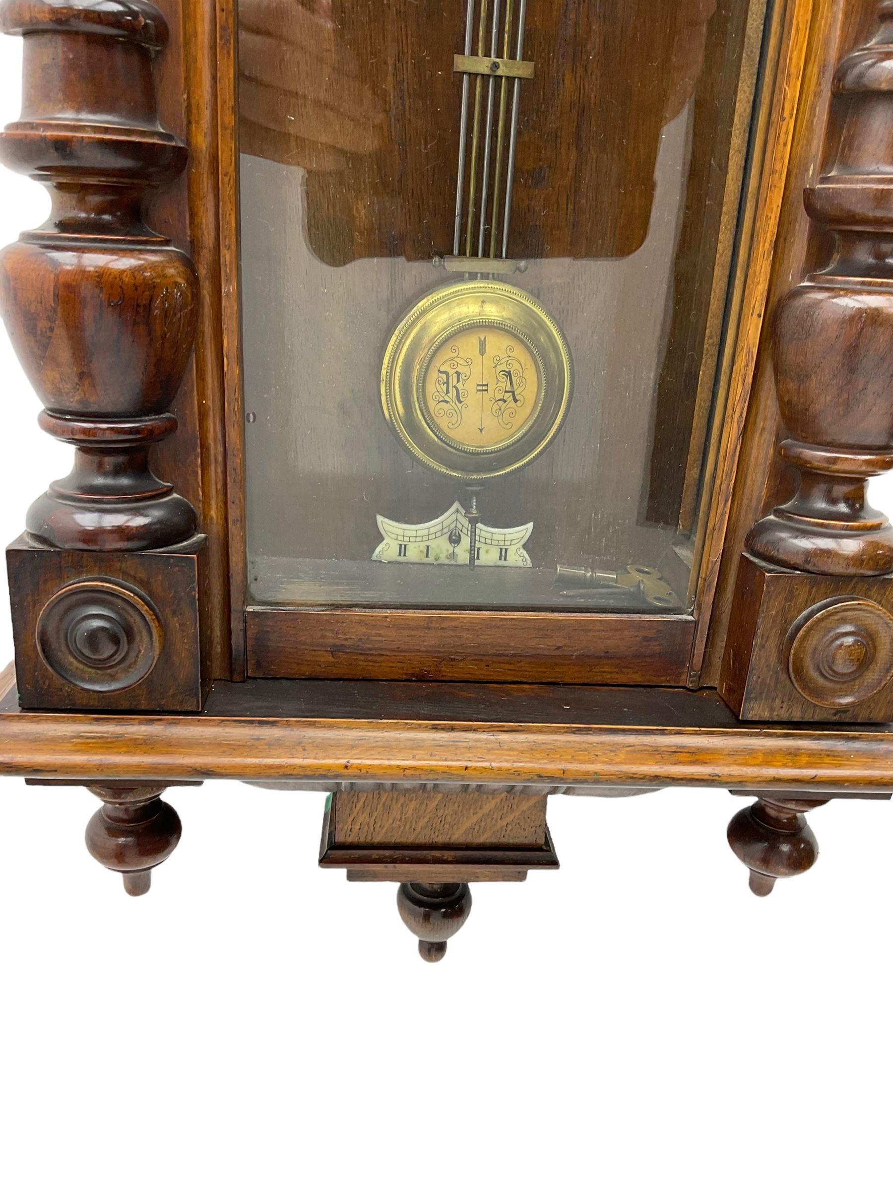 Small Spring driven German wall clock in a mahogany case with turned