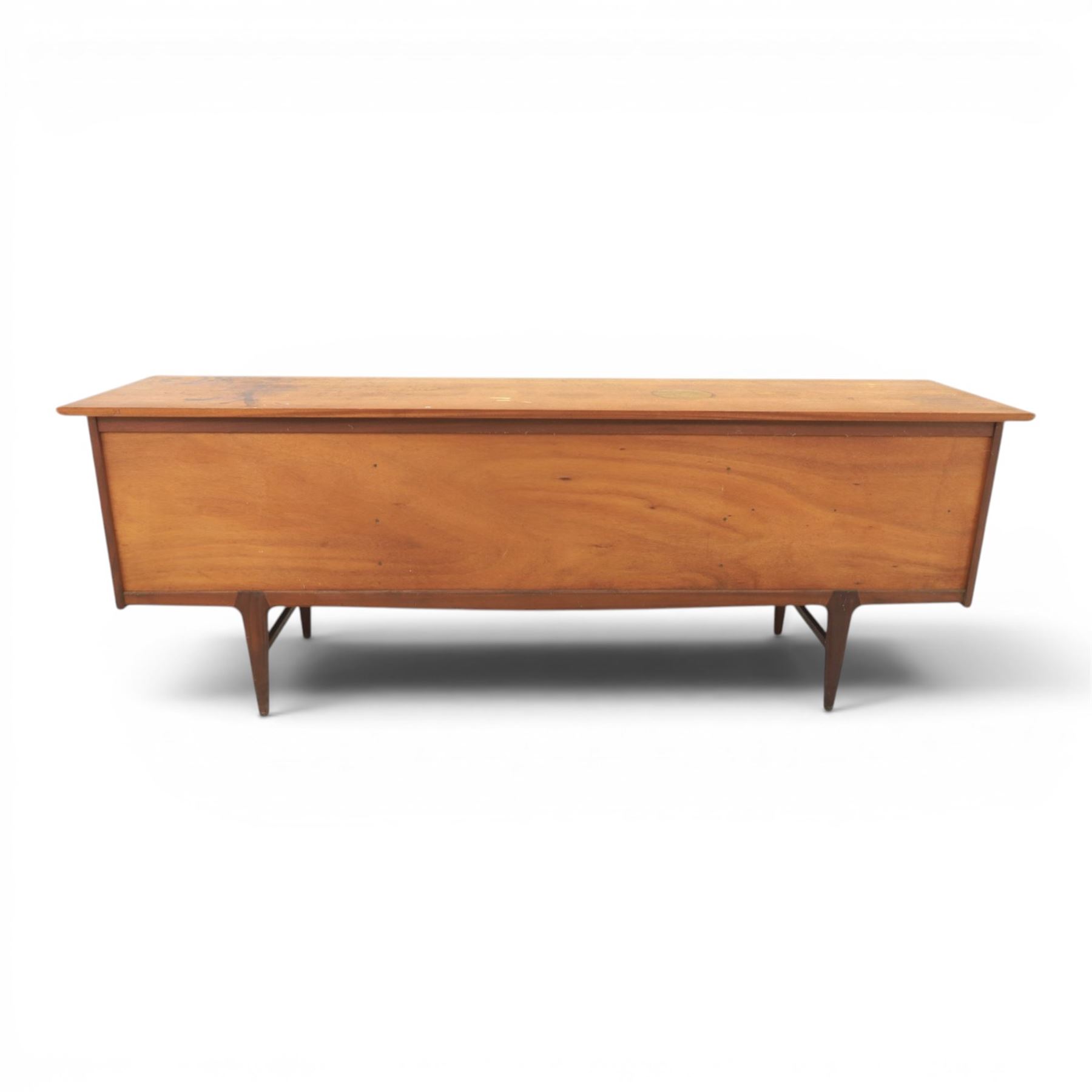 John Herbert for Youngers - 'Fonseca' mid-century teak sideboard, rectangular top above a central bank of three drawers one fitted for cutlery, flanked by cupboards with fixed shelved interior, raised on tapering supports 