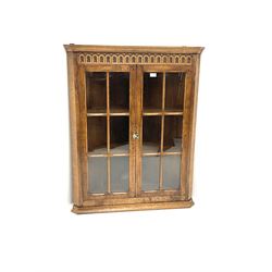 Late 20th century medium oak wall hanging corner cupboard, moulded cornice over arcade carved frieze, enclosed by two astragal glazed doors, two shelves 