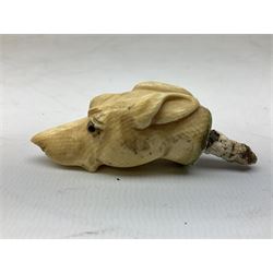19th century carved ivory walking cane handle, modelled as the head of a greyhound with inset glass eyes, together with a further 19th century ivory example, modelled as a caricature of a gentleman's head, (2)