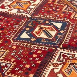 South West Persian Cori hand-knotted rug, red field with three central stepped lozenge medallions enclosing stylized geometric motifs surrounded by scattered rosette devices and angular ornaments within multiple geometric borders, with fringe ends  