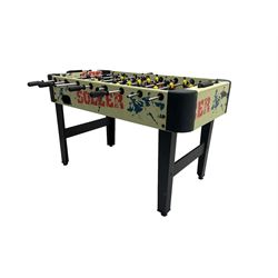 Sportcraft table football game raised on supports with stretcher