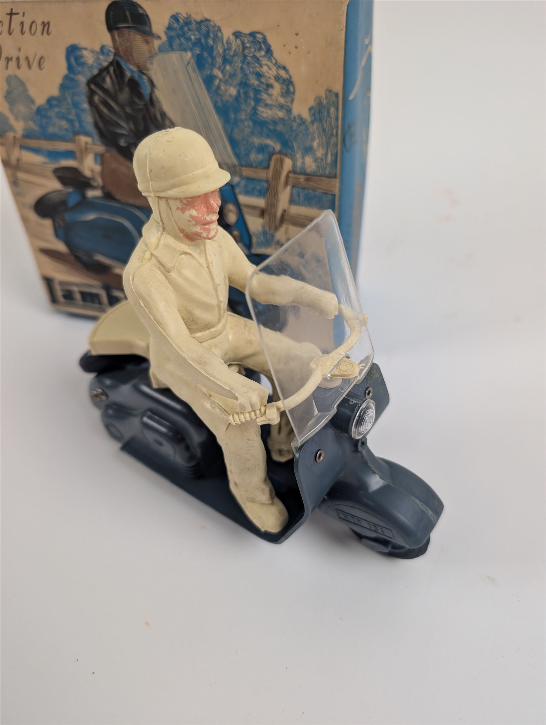 Mettoy friction drive Lambretta scooter no. 8134, the blue plastic scooter with cream handlebars and clear windshield, the rider with cream hat and clothing, stamped MTY 143 to front mud guards, in original box