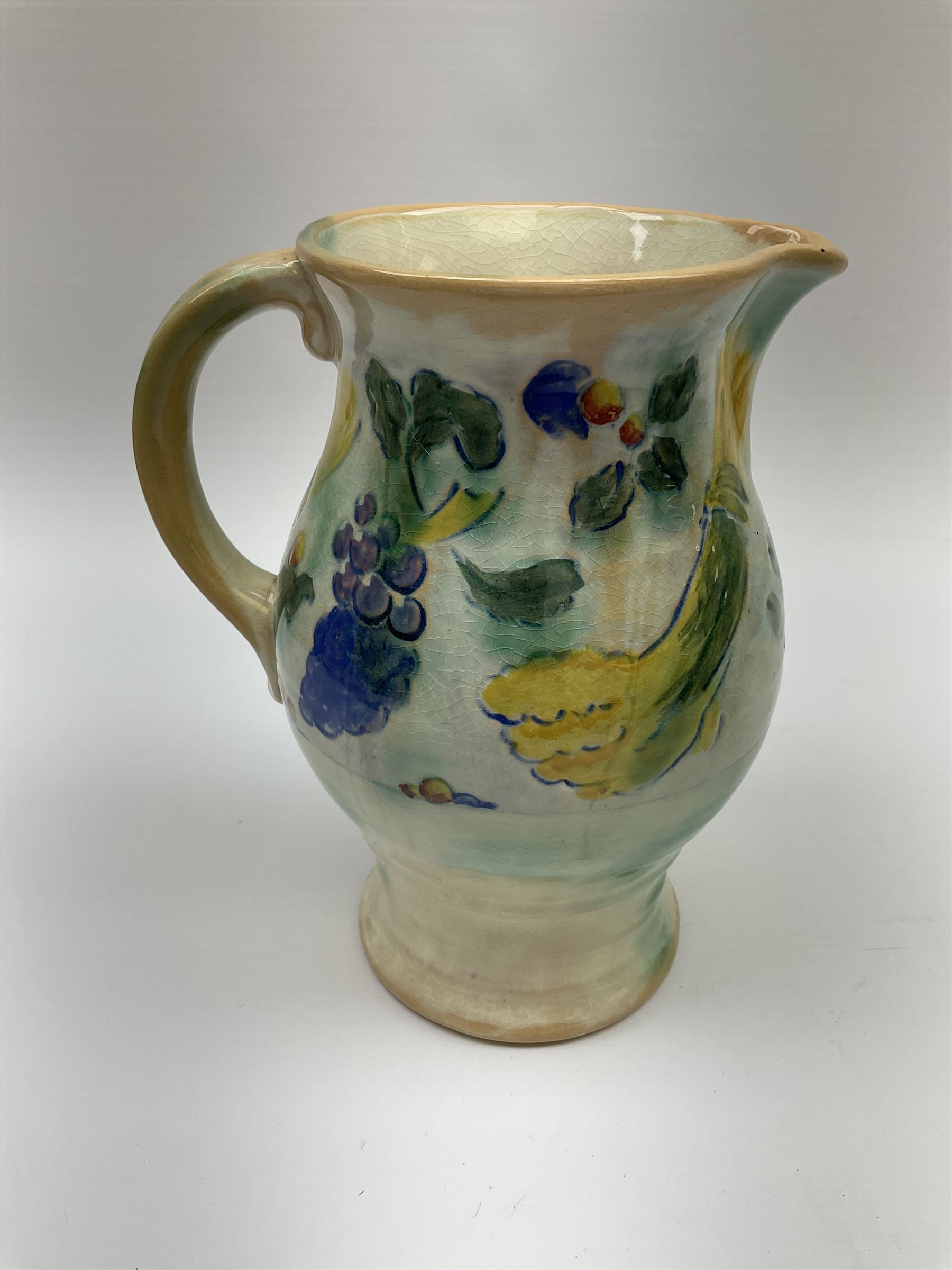 Early 20th century Royal Doulton Brangwyn Ware jug and set of six beakers, designed by Frank Brangwyn RA, all decorated in the Harvest pattern with stylised leaves and fruit on mottled peach and green ground, all with printed marks beneath, date code for 1920s, largest H18cm
