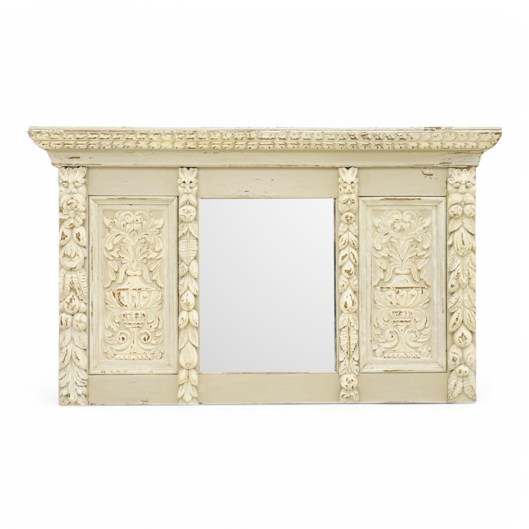 Victorian heavily carved oak wall mirror in distressed grey paint finish, moulded and chip carved cornice over central bevelled mirror and panelled front, the panels carved with urns and scrolled foliage, the uprights with fruiting foliage carved mounts 