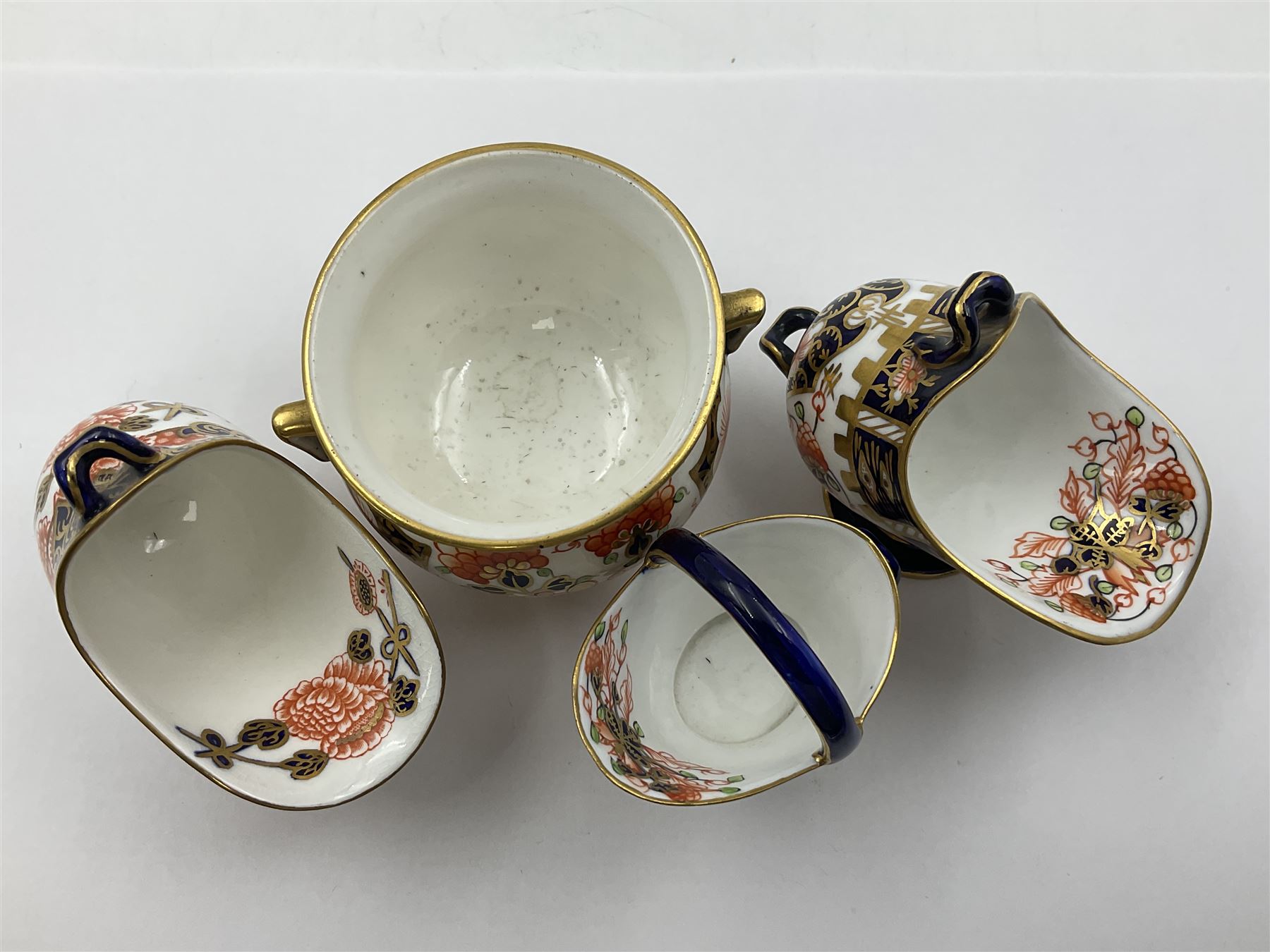 Group of Crown Derby and Royal Crown Derby Imari pattern miniatures, including mid 19th century Stevenson and Hancock cauldron, with painted mark beneath, H5.5cm, a near pair of early Royal Crown Derby scuttles, decorated in the 6299 pattern, each with printed and painted marks beneath including illustration date codes for 1913 and 1922, tallest 6.5cm, and a further early 20th century Royal Crown Derby scuttle, decorated in the 6299 pattern, with printed and painted marks beneath including illustration date code for 1922, H5.5cm, (4)
