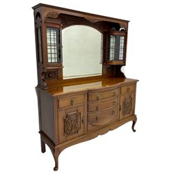 Late Victorian walnut mirror back sideboard or dresser, the raised back fitted with two curved and lead glazed cabinets, central arched bevelled mirror, the sideboard with break bowfront, fitted with six drawers and two cupboards, the cupboard doors panelled and carved with scrolls, shell and plant motifs, shaped apron with cabriole feet
