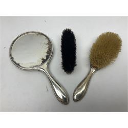Silver mounted dressing table hand held mirror, together with a matching silver mounted hair brush, and a silver mounted clothes brush, all hallmarked 