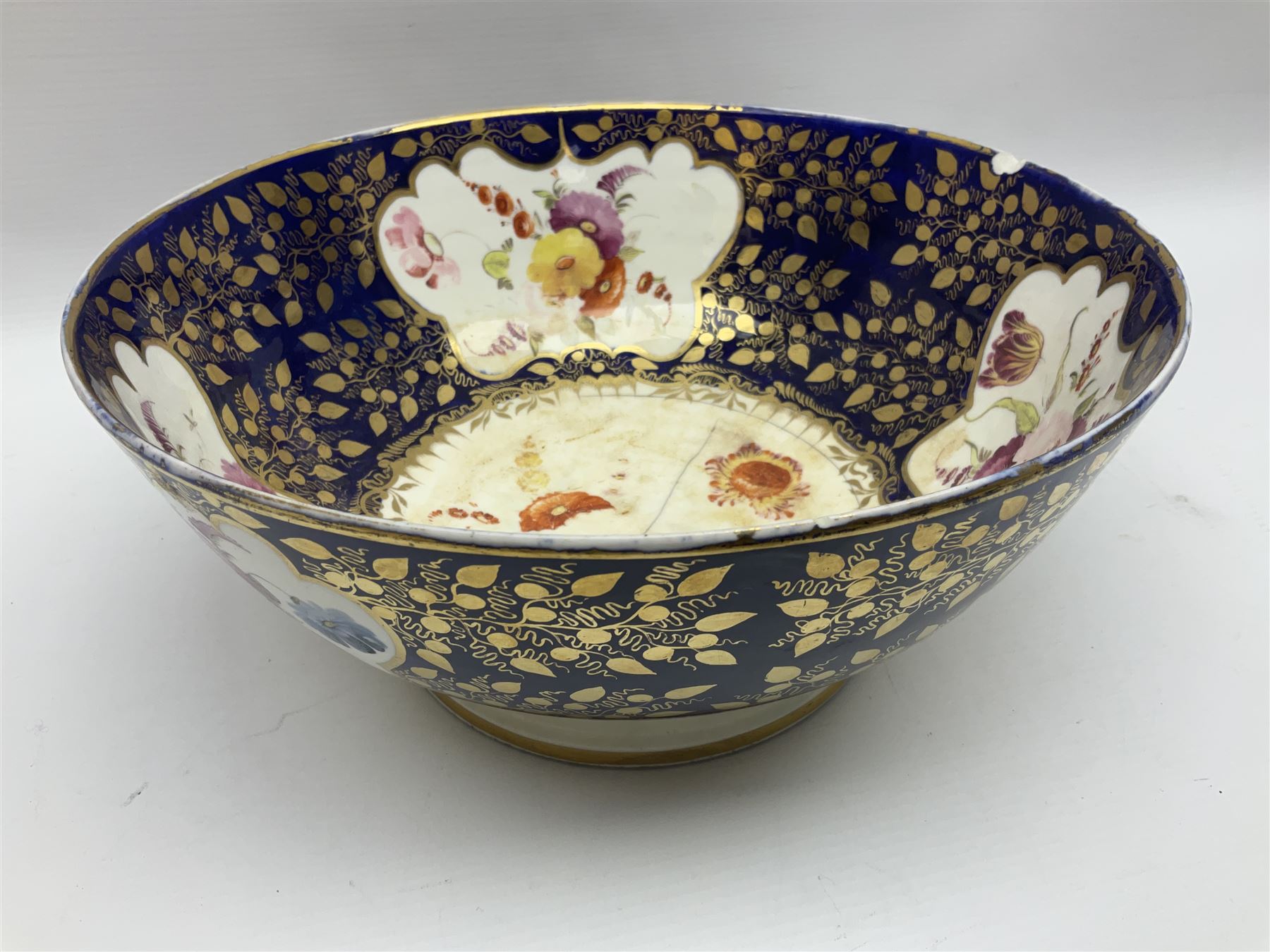19th century continental bowl, decorated with hand painted floral sprays amongst gilt foliate decoration on a cobalt blue ground, D27.5cm
