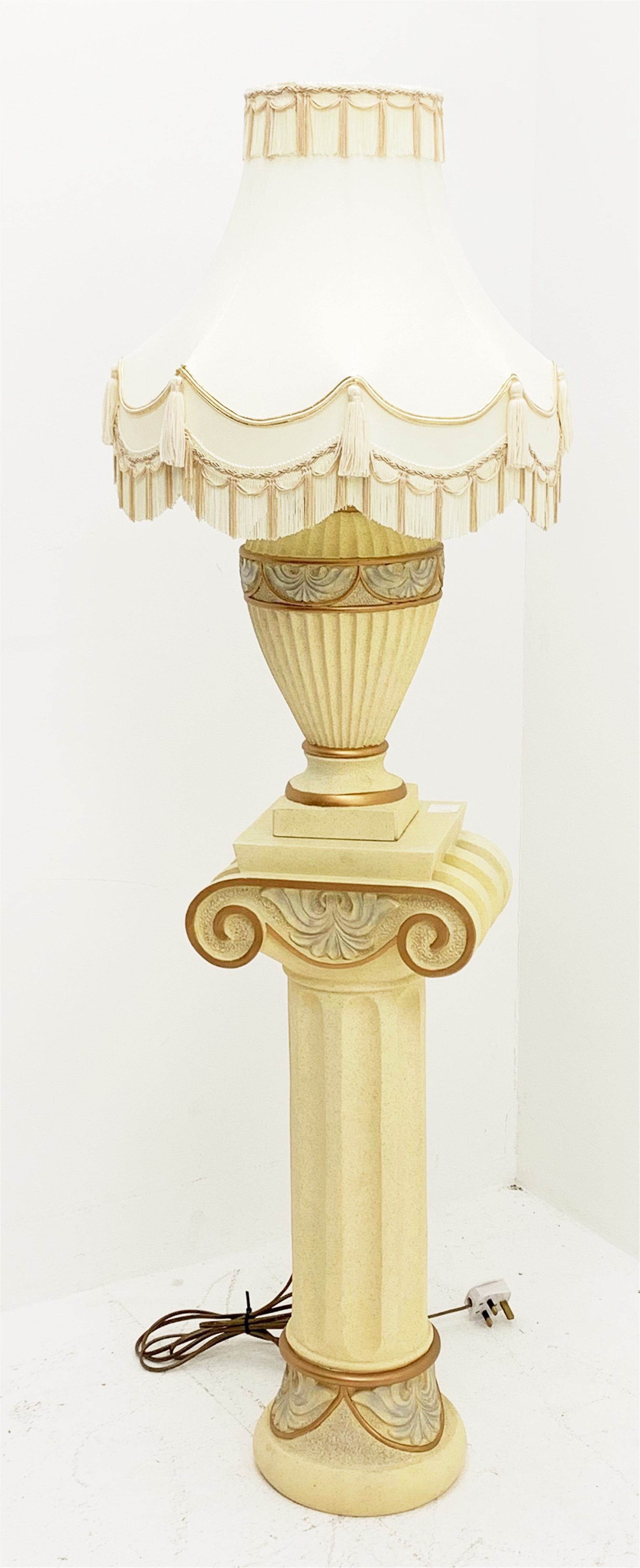 A composite cream Ionic column stand, H68cm, together with a matching table lamp of baluster form with cream tasselled shade, including shade H70cm. 