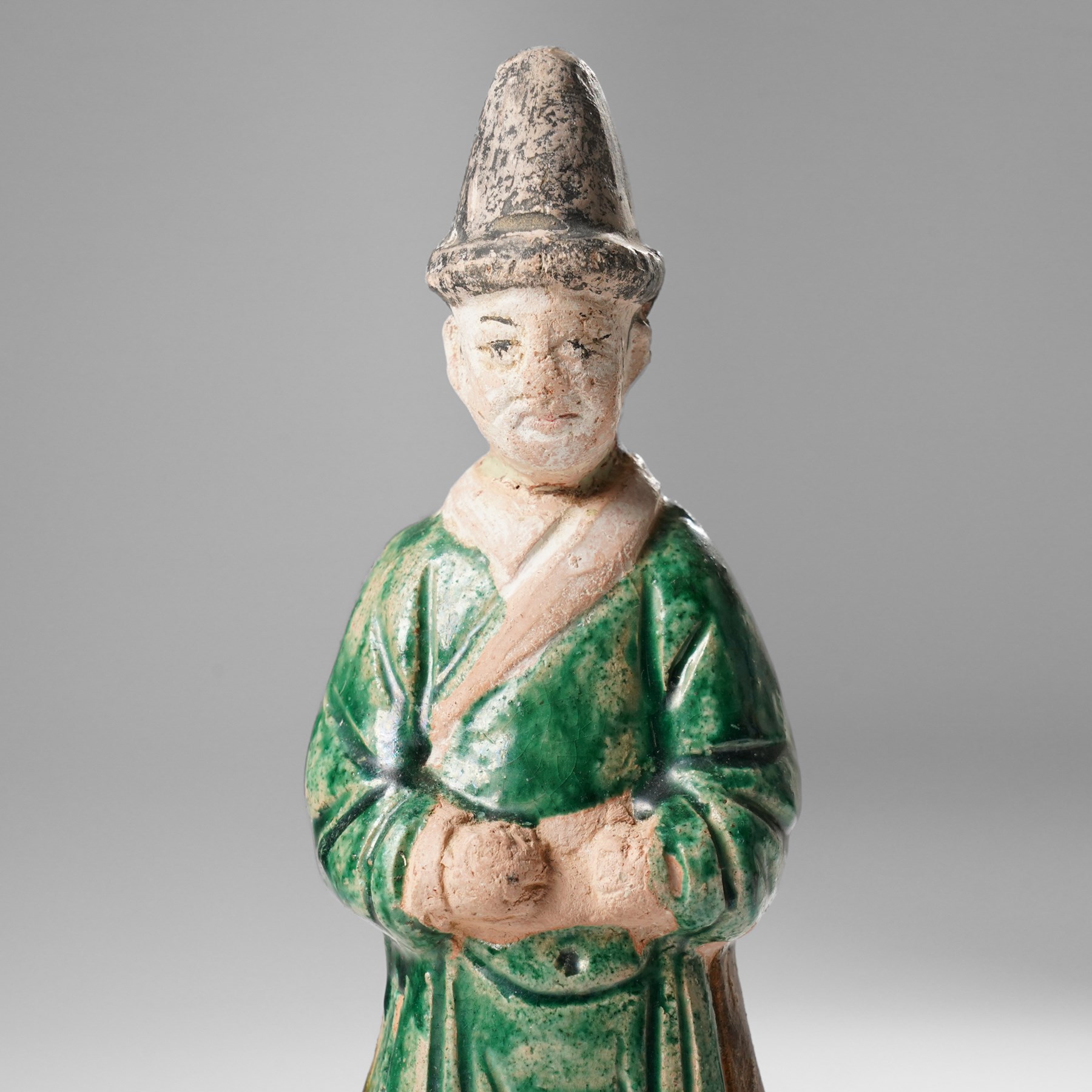 Pair of Chinese terracotta court attendant tomb figures,  probably Ming Dynasty, in Sancai green glaze, upon stepped square bases, H22cm 