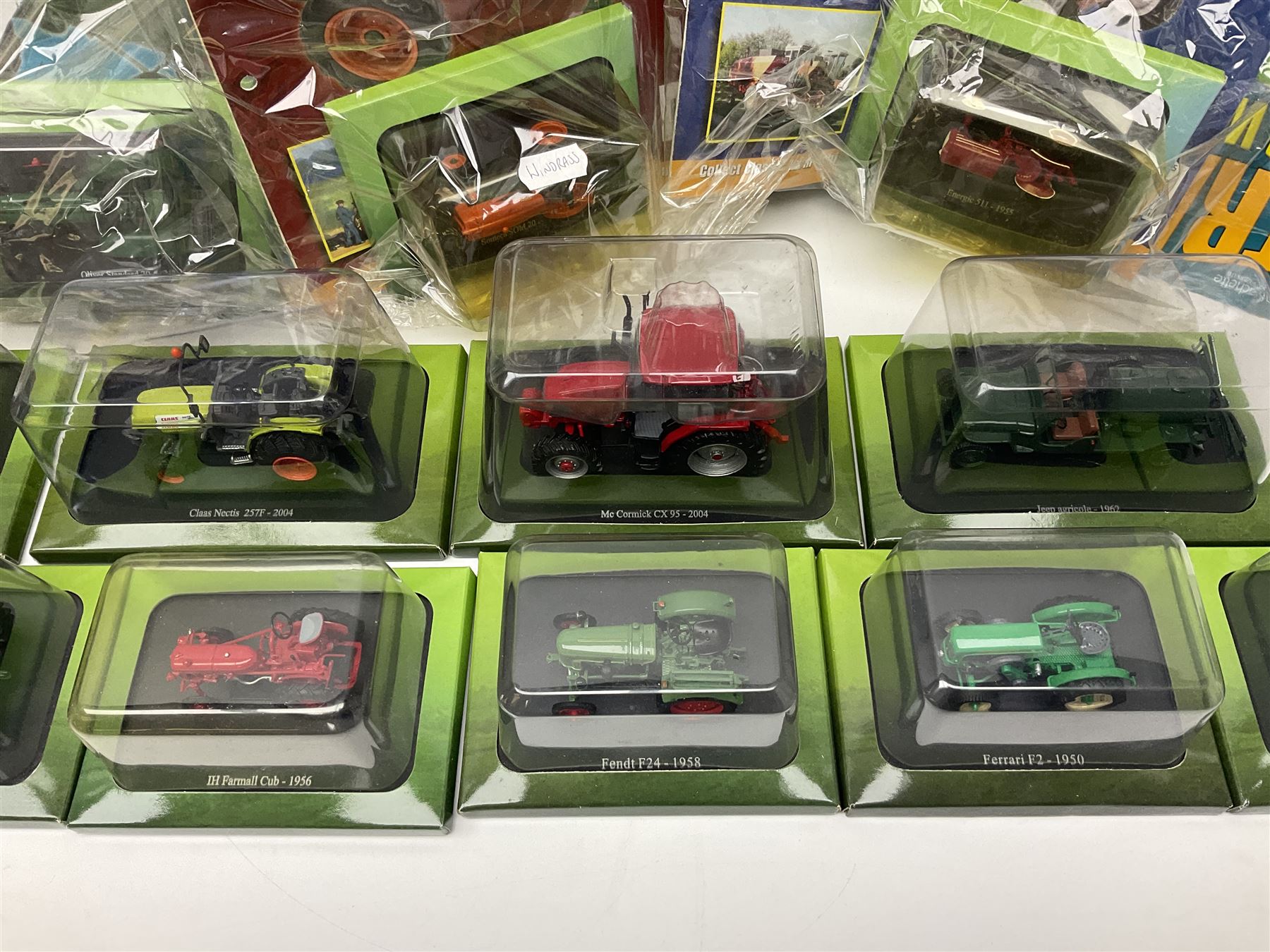 Eighteen issues of Tractors and The World of Farming magazine, together with sixty diecast tractors, all in original packaging, in three boxes 