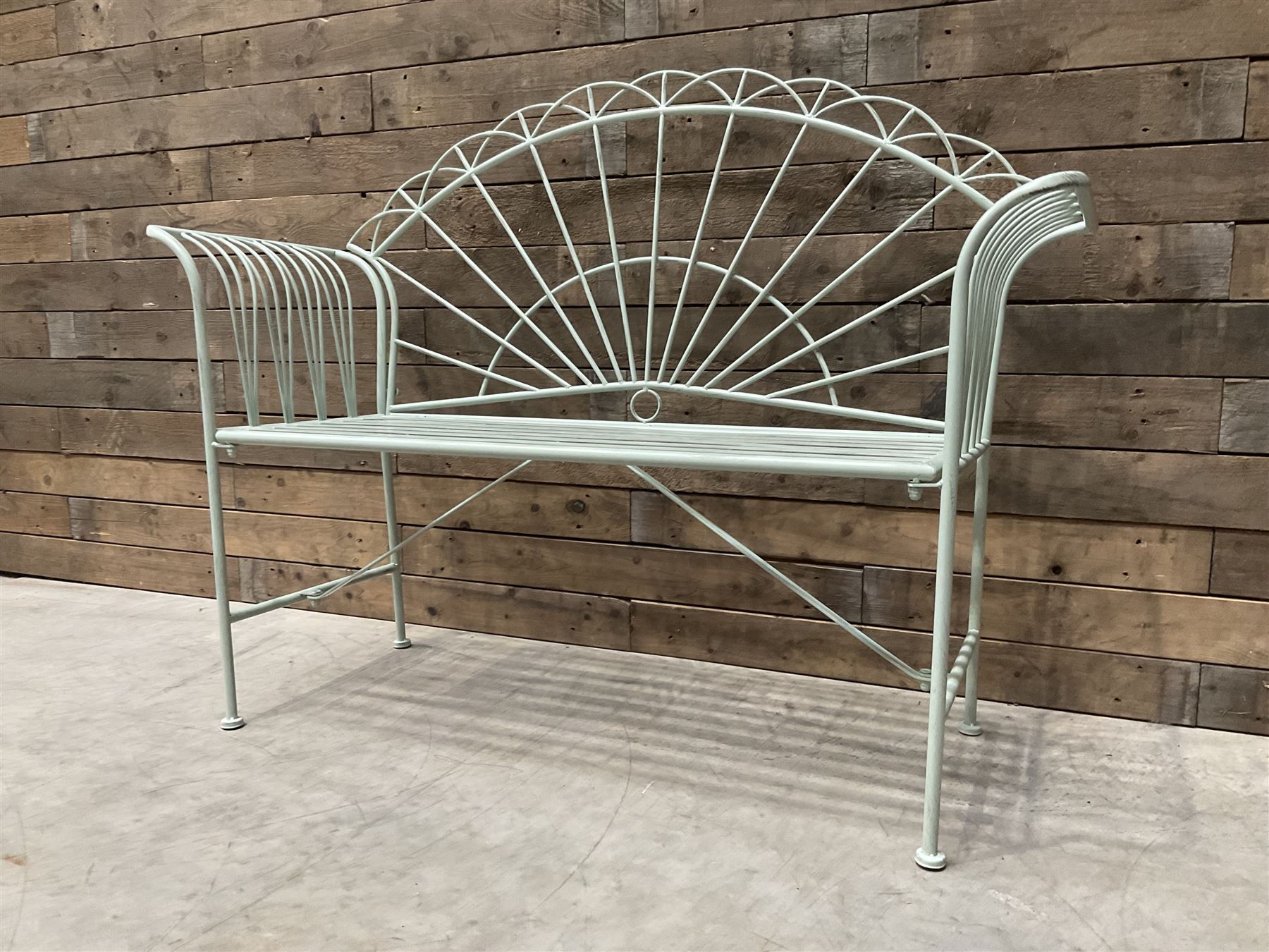 Wrought metal two seat garden bench, sunburst back, painted in pale green finish