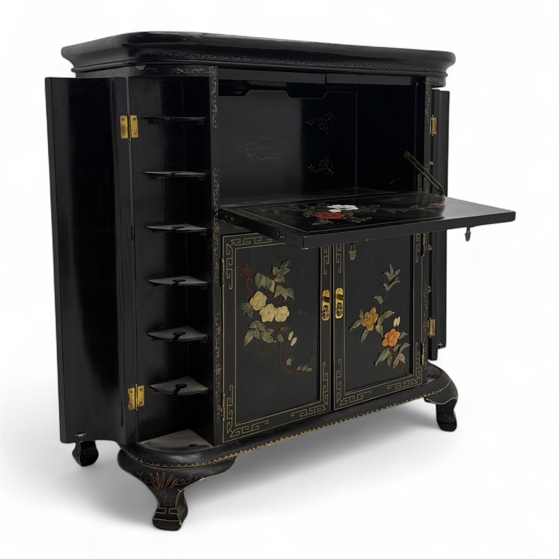 Early 20th century Chinoiserie lacquered cabinet, rounded rectangular top above a fall front enclosing fitted interior with lacquered decoration, over a pair of cupboard doors and flanked by side compartments with tiered bottle shelves, the black lacquer ground decorated throughout with raised and painted floral sprays, on shaped bracket feet