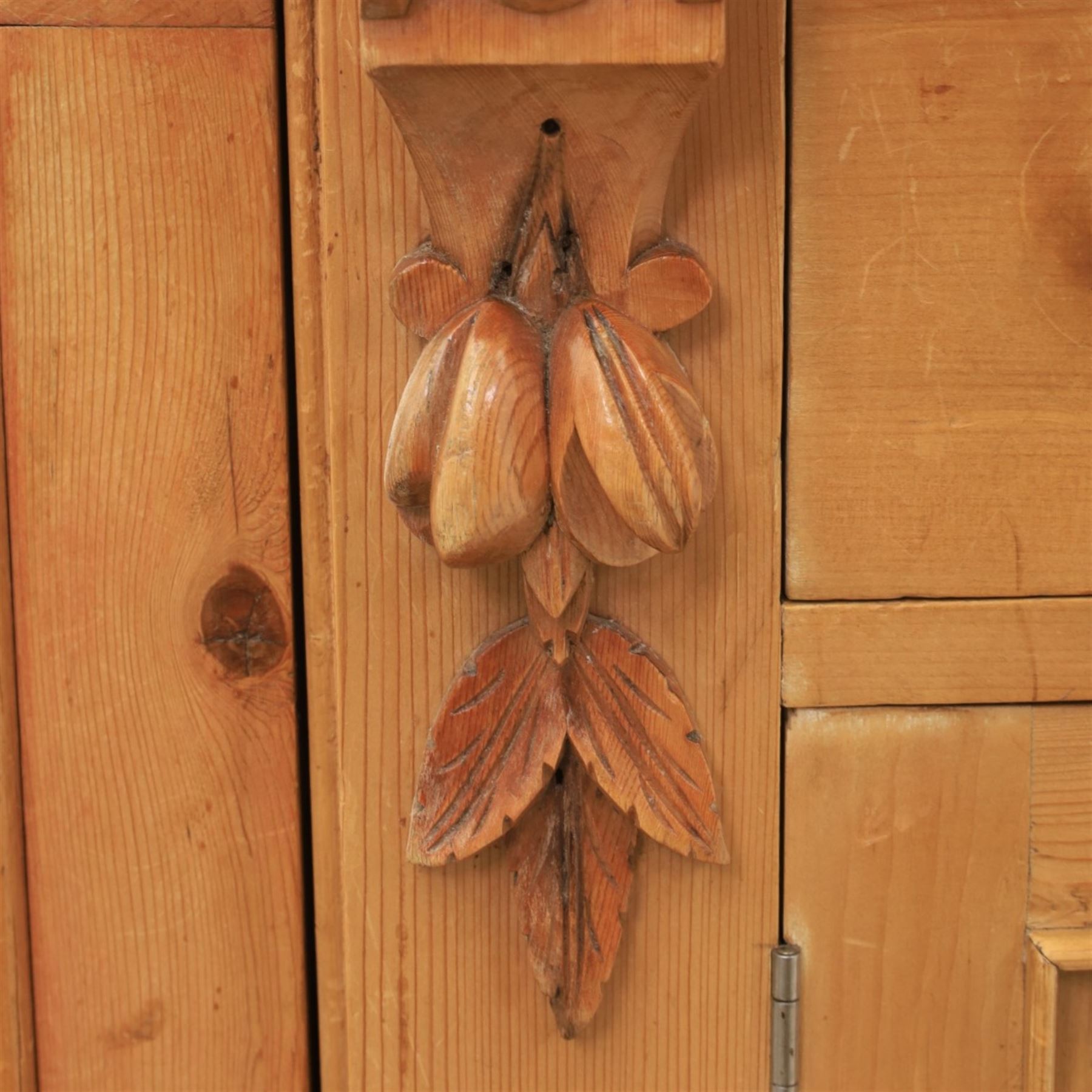 Victorian pine chiffonier, shaped moulded top with raised scroll carved back surmounted by carved fruit and foliate crest, fitted with two frieze drawers over two panelled cupboard doors, the outer cupboards of bowed form, carved foliate corbels, on plinth base
