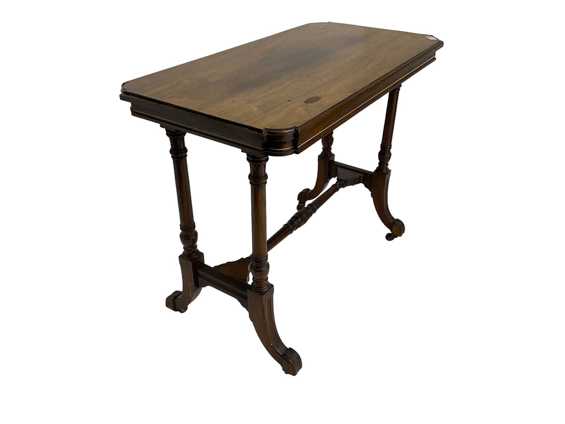 Late Victorian rosewood stretcher table, the rectangular top with curved canted cornice and moulded edge, on quadruple turned pillar supports carved with foliage, joined by collar turned stretcher, on splayed moulded supports with brass and ceramic castors