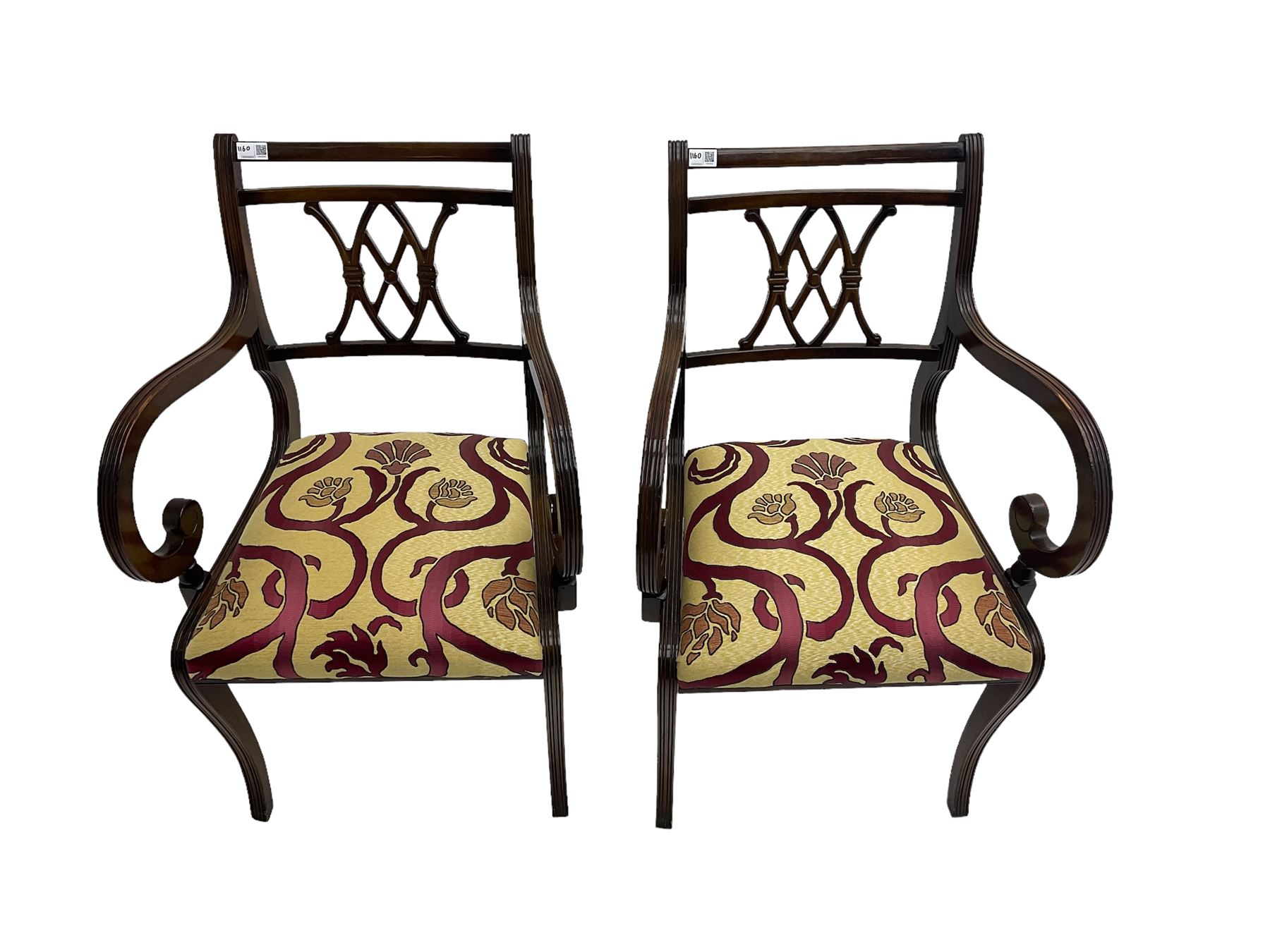 Regency design mahogany twin pedestal dining table, rectangular top with reeded edge, acanthus carved turned column terminating in reeded tripod base with hairy paw feet and castors (W172cm D92cm H75cm) and set eight (6+2) Regency design mahogany dining chairs, pierced back with scroll design, seat upholstered in patterned laurel green fabric, raised on reeded sabre supports (W48cm H88cm)