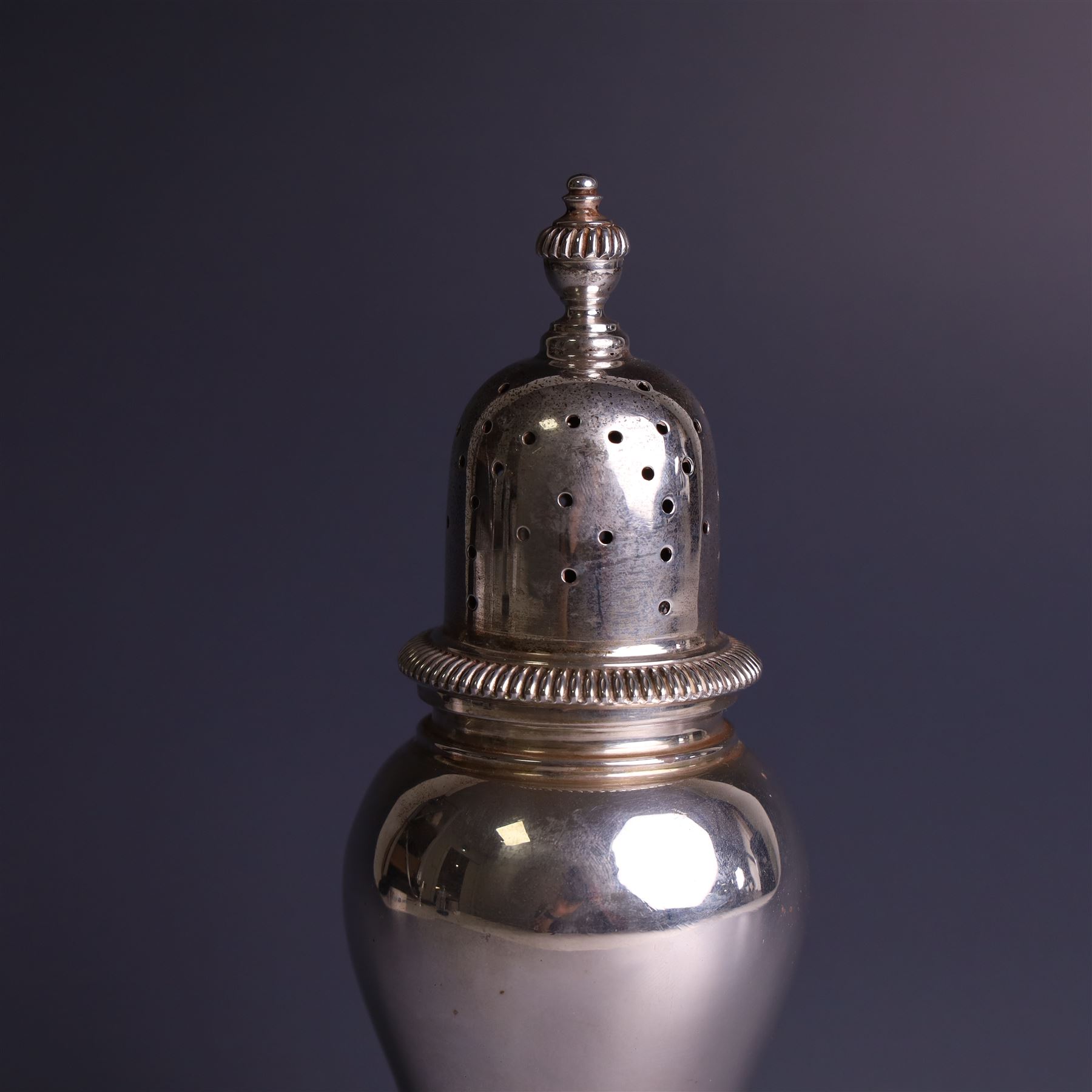 Mid 20th century silver sugar shaker, of typical baluster form, the removable pierced cover with urn finial, hallmarked William Comyns & Sons Ltd, London 1961