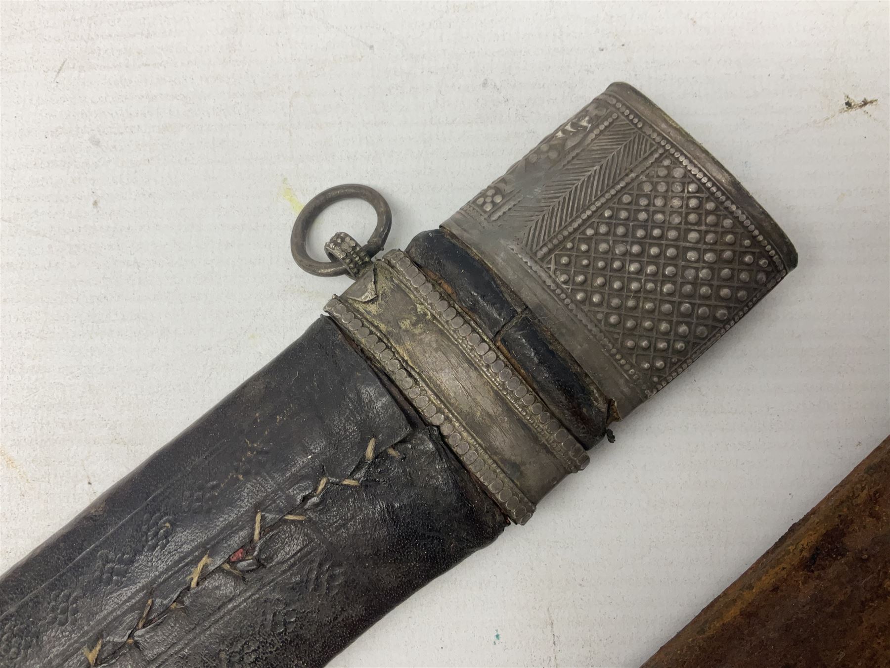 Omani presentation sword kattara, with 77cm  broad slightly curved single edge blade with two fullers, leather bound hilt woven with silver wire decoration and iron pommel;  in tooled leather scabbard with chased silver mounts and presentation plaque 'To Capt. D.M. Naylor From C Company NFR Oman Dec 1962' (Northern Frontier Regiment) L99cm overall