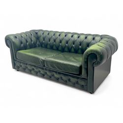Two seat Chesterfield design sofa bed, upholstered in emerald green leather with deep-buttoned detailing, rolled arms, two loose seat cushions, and pull-out 