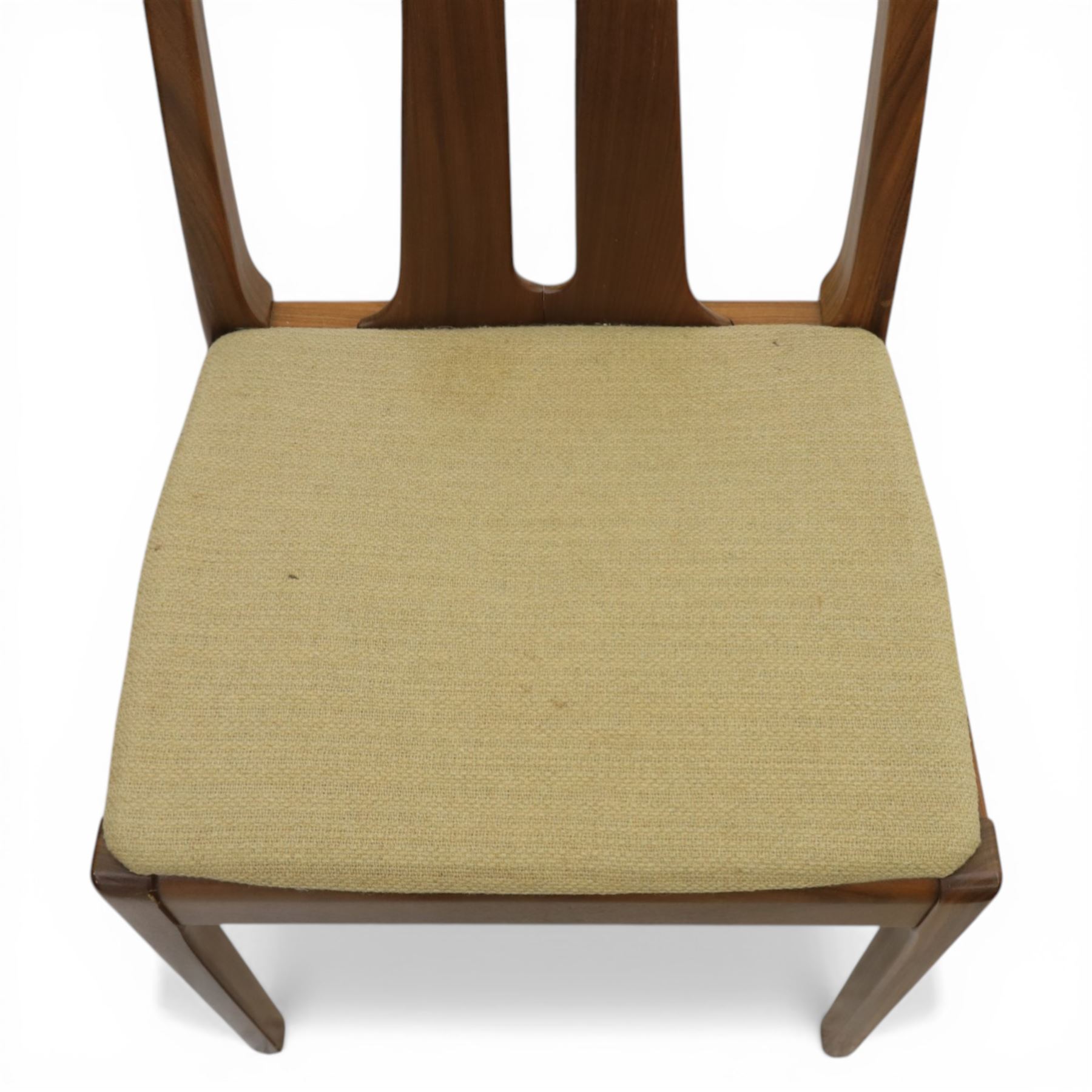 Nathan - teak drop leaf dining table and four Nathan dining chairs, the rectangular top with rounded corners fitted with twin hinged drop leaves and gate legs, extended to form an oval table 174cm in length, raised on square section supports united by stretchers, the chairs with teak frames and padded beige upholstered seat (H 96cm, W 48cm)