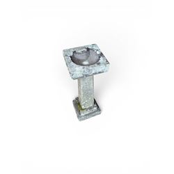 19th century weathered sandstone birdbath, formed in four sections, square top with carved shell bath, raised on tapering column with stepped base