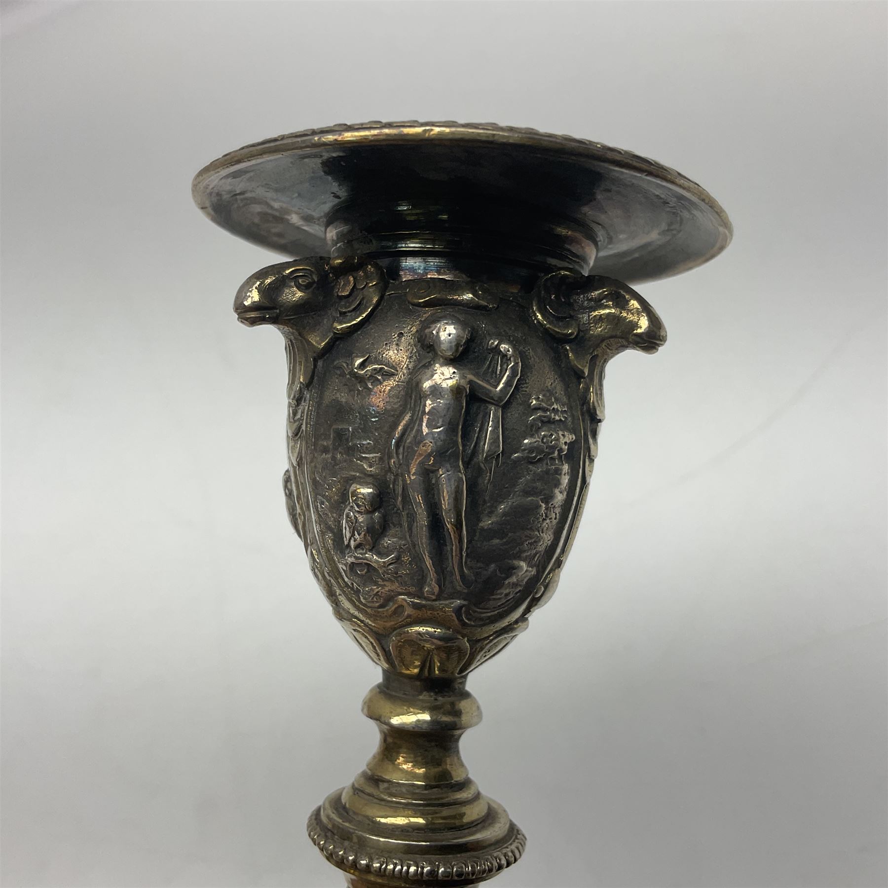 Pair of Victorian Elkington Mason & Co silver plated candlesticks, decorated in relief with ram masks and figures, H14cm