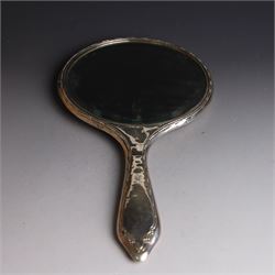 Five silver mounted dressing table items, including 1920s mirror and hairbrush set, with engraved initial to reverse, pair of clothes brushes with engraved initials and engine turned decoration and an oval clothes brush, all hallmarked 