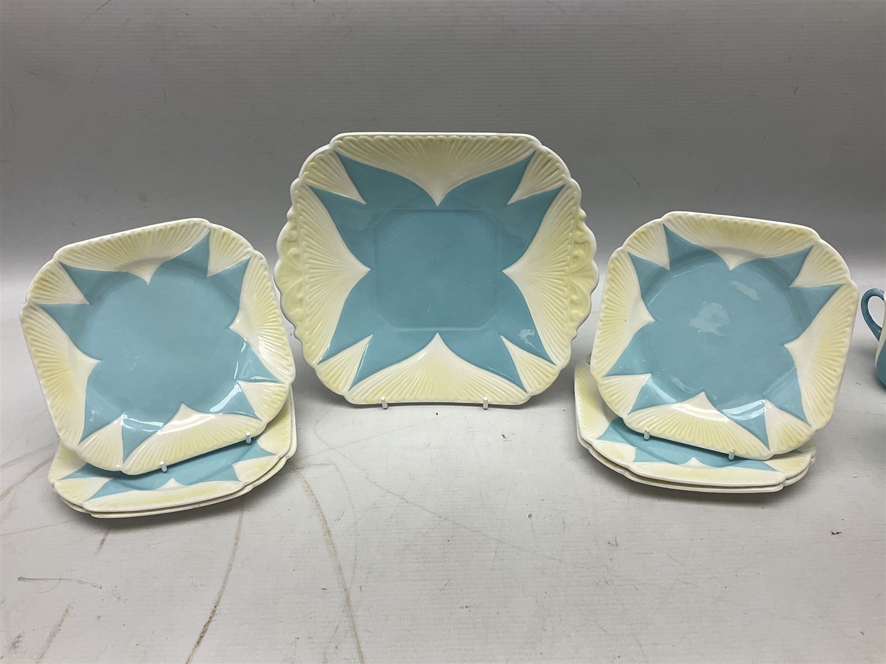 Shelley Dainty pattern tea wares, of lobed form with blue star decoration on merging white and yellow ground, comprising five teacups, five saucers, six tea plates, milk jug and cake plate, all with printed green mark beneath, some with painted pattern no 11770