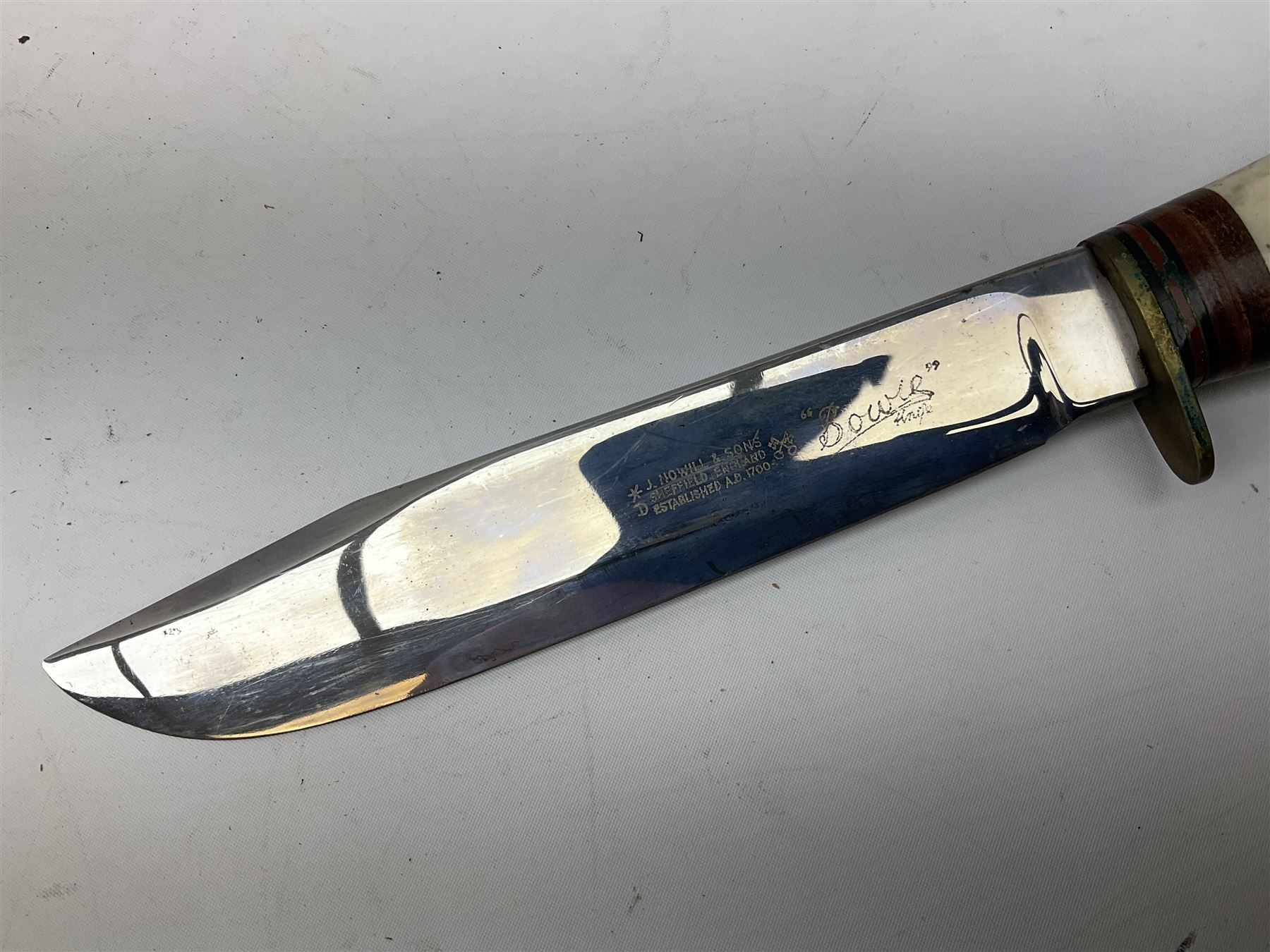 Bowie knife by J. Nowill & Sons Sheffield England Est. AD1700,  with 17.5cm steel blade, brass cross-piece, antler grip and alloy pommel; in leather sheath L32cm overall