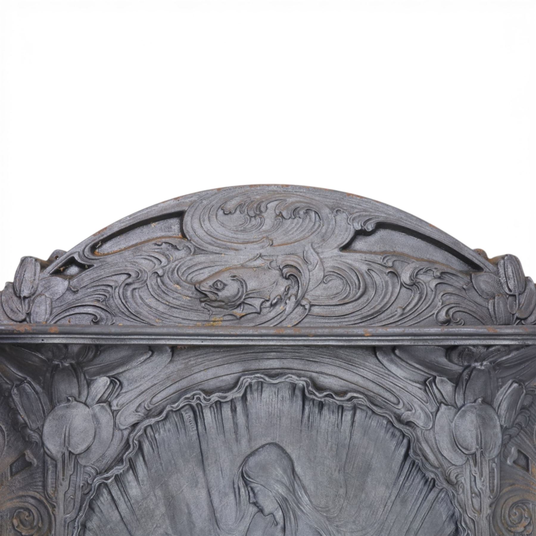 Art Nouveau cast iron fireplace, shaped hood with scrolling foliate crest, relief cast panel of female figure seated within shell form amidst wave motifs, uprights cast with foliate designs