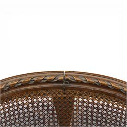 Late 19th century cane bergère armchair, the serpentine shaped back flowing into enclosed arms, the back and seat caned throughout, with carved detail to the crest and arm terminals, on turned legs