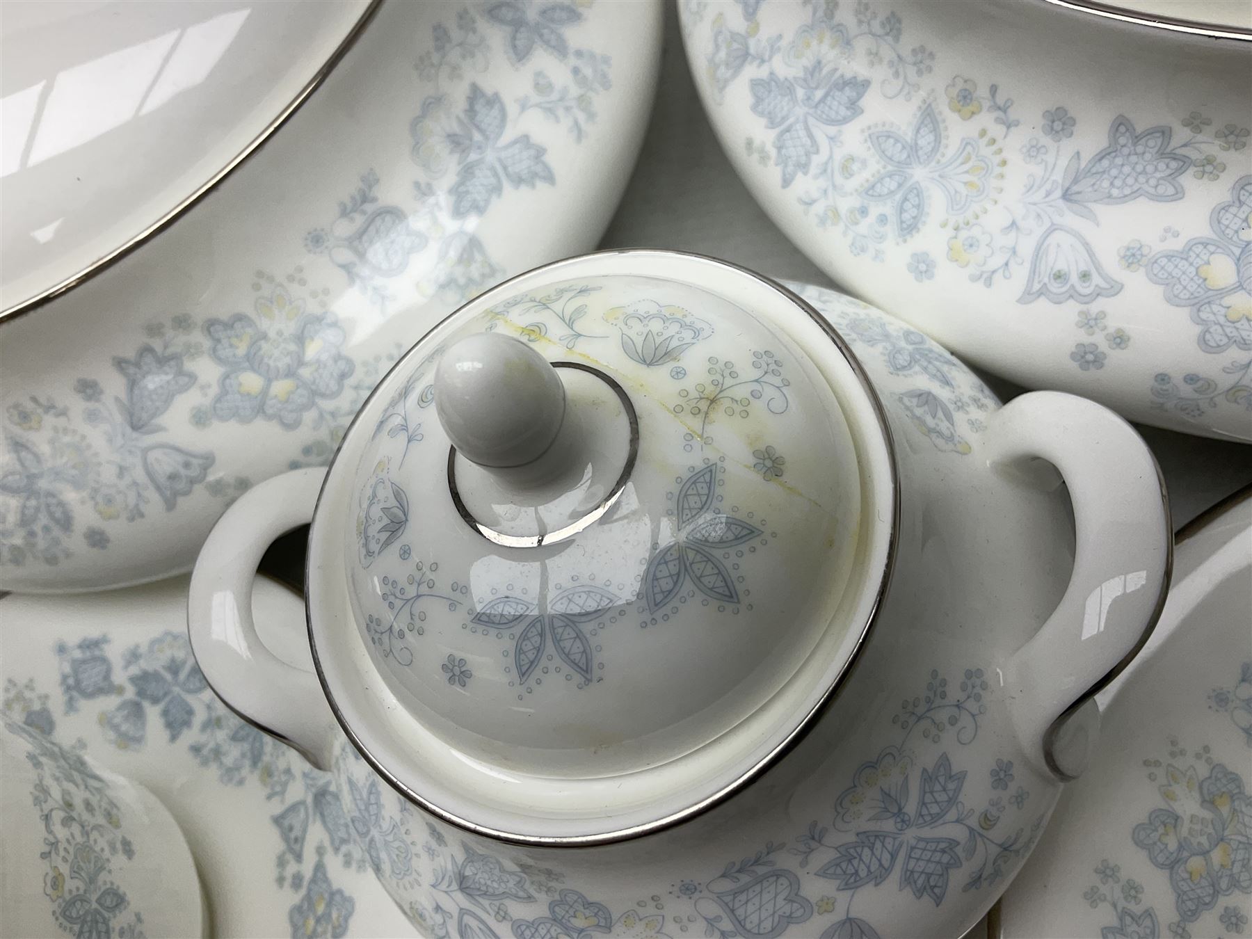 Royal Doulton tea and dinner wares in the Meadow Mist pattern, no H5007, comprising seven dinner plates, eight side plates, two lidded tureens, two jugs, lidded sucrier, oval serving dish, six teacups, seven saucers, seven tea plates and large saucer