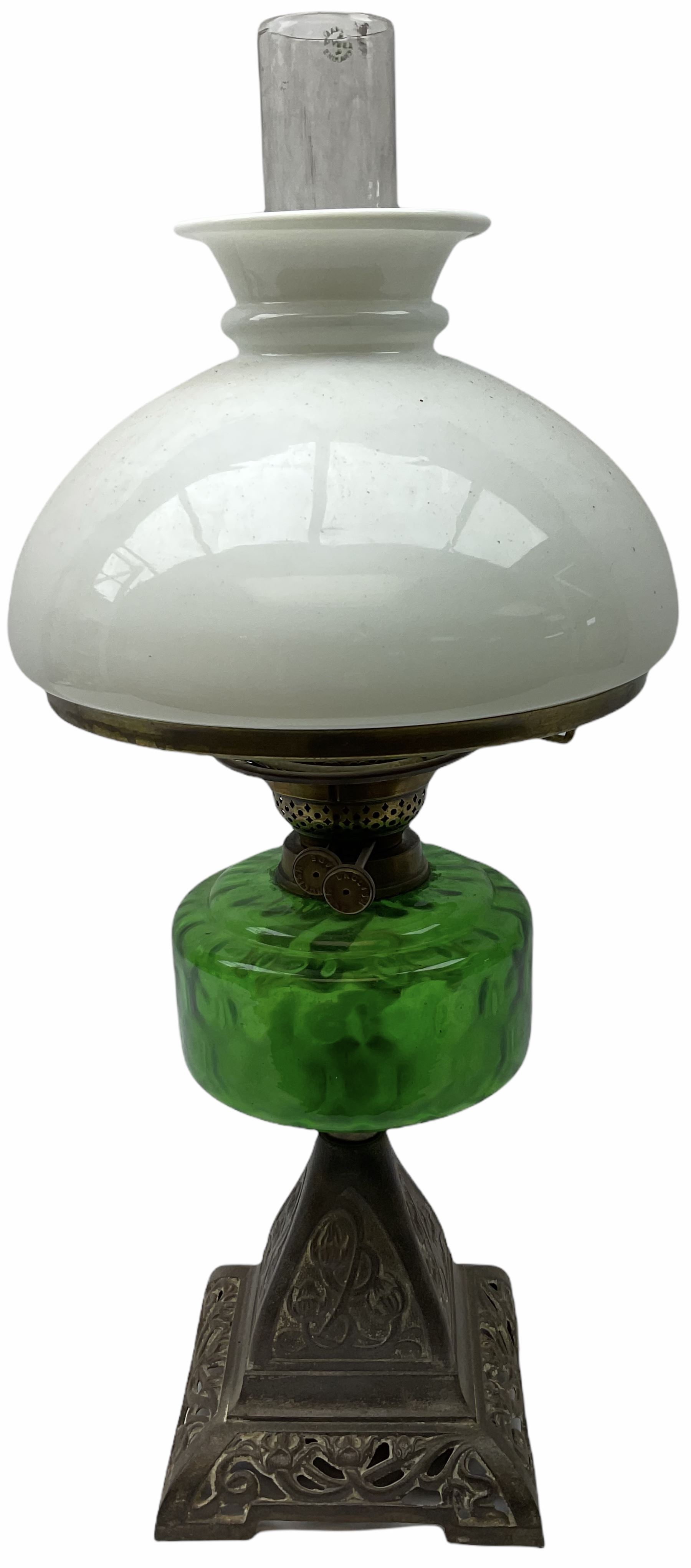 Late Victorian oil lamp, the cast metal base decorated with foliate tendrils, supporting a green glass reservoir, and opaque glass shade and clear class chimney, H60cm. 