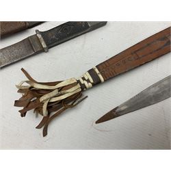 Indian kukri with 29cm curving steel blade and nickel mounted horn grip; in leather covered scabbard with one skinning knife L42cm overall; Hitler Youth knife with scabbard in relic condition; and three African graduated knives each with crudely carved wooden grips and painted leather covered scabbards (5)