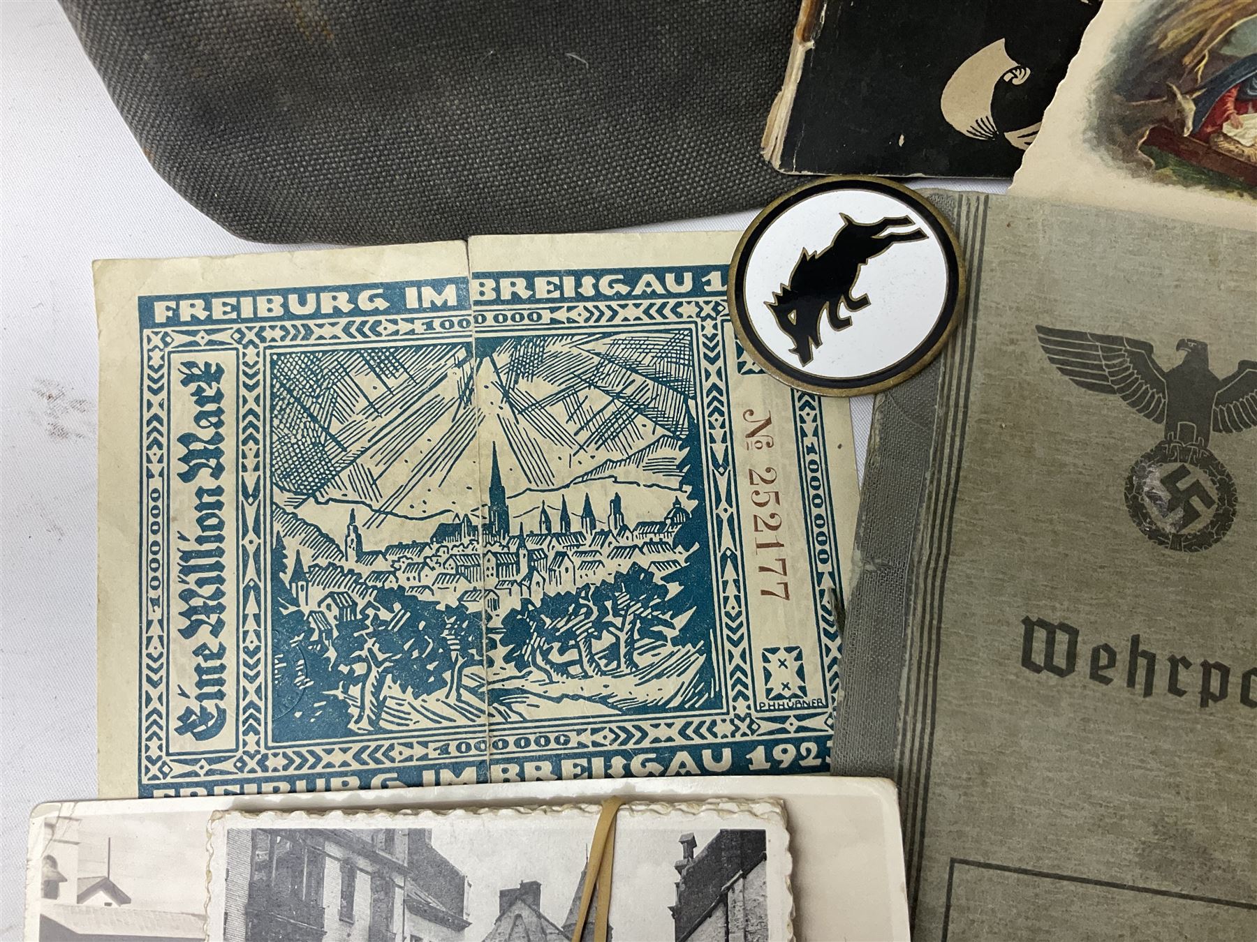 WW2 German War Pass (Wehrpass) identification paperwork for Walter Fensterseifer 2nd type booklet dated 8/6/1940, with signed photo of recipient in civilian suit. Born 31st January 1921. Numerous entries; together with quantity of small private photographs of German soldiers; One Million mark banknote 1923; 30th Corps in Germany booklet with Formation badge; and other WW2 paper ephemera