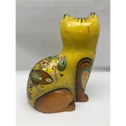 Papier mache model of a sitting cat, with painted floral and butterfly decoration, signed Serimel to base
